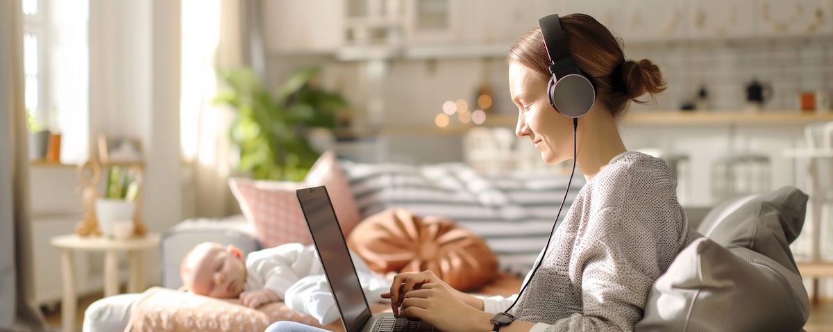 Elternteil lernt online am Laptop, während das Baby schläft