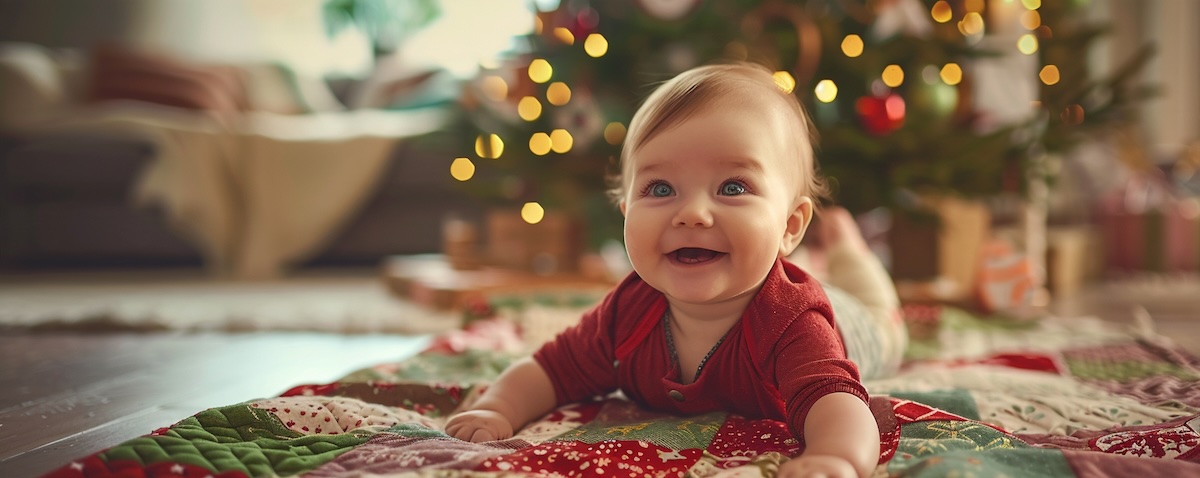 Baby liegt auf einer selbst genähten weihnachtlichen Krabbeldecke im festlich geschmückten Wohnzimmer