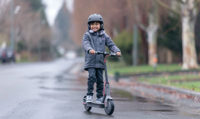 Junge auf einem e-scooter für kinder